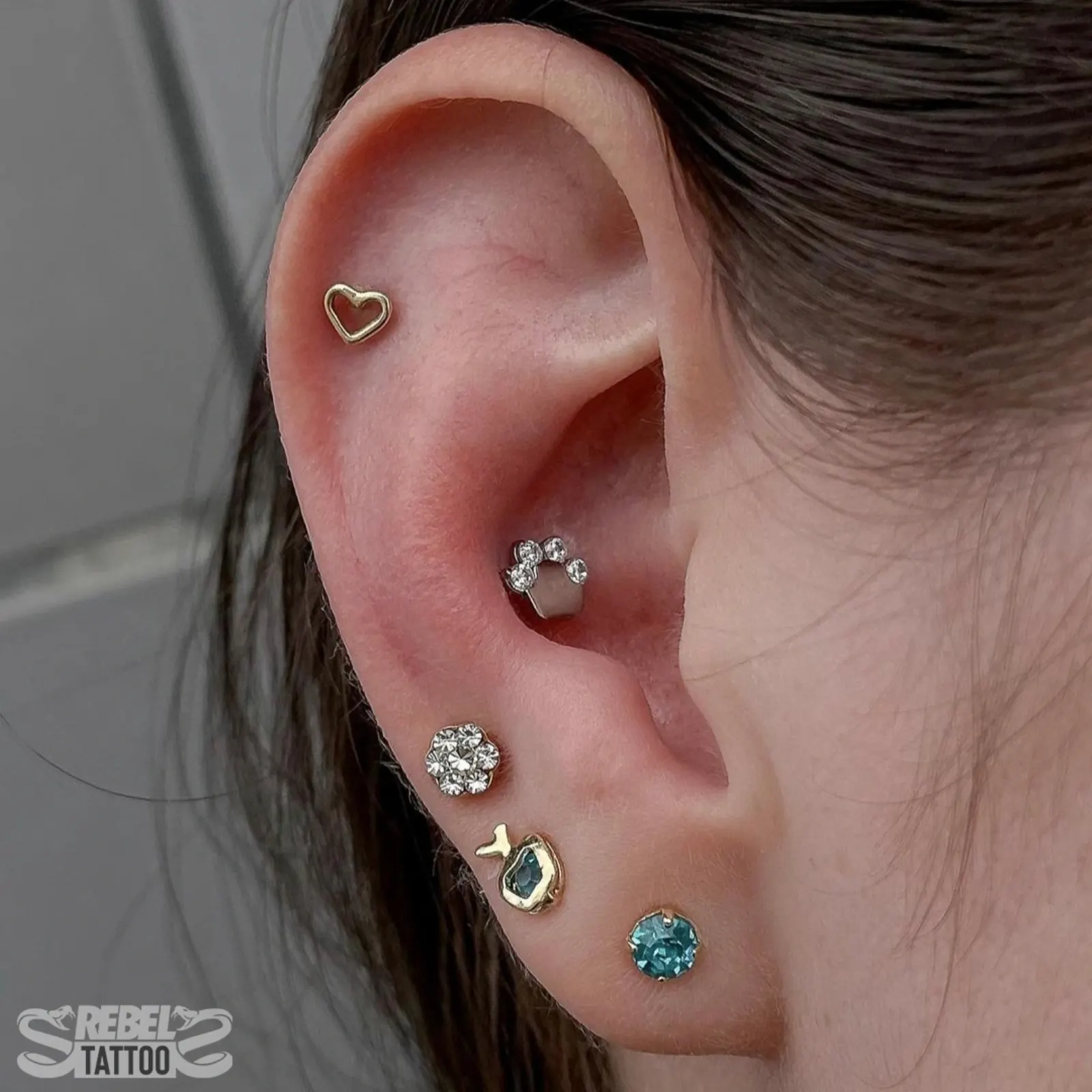 Helix piercing with aquamarine stud in implant grade titanium, ear curation at Rebel Tattoos Gurgaon