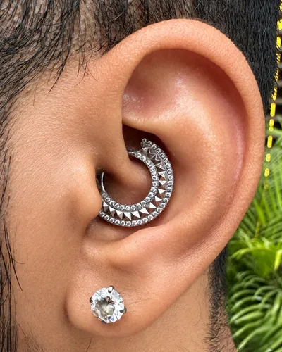 Daith piercing with a pave clicker ring in implant-grade titanium at Rebel Tattoos Gurgaon