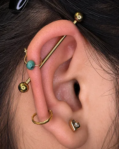 Industrial piercing with an anodised titanium barbell at Rebel Tattoos Gurgaon