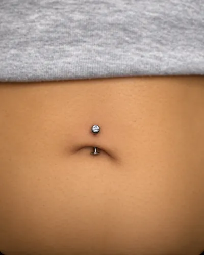 Navel piercing with a curved barbell in implant-grade titanium at Rebel Tattoos Gurgaon