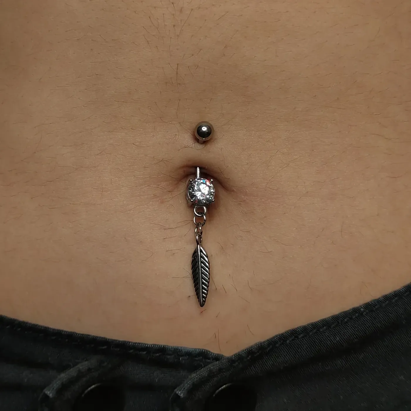 Belly piercing with charm barbell in implant grade titanium, navel piercing at Rebel Tattoos Gurgaon