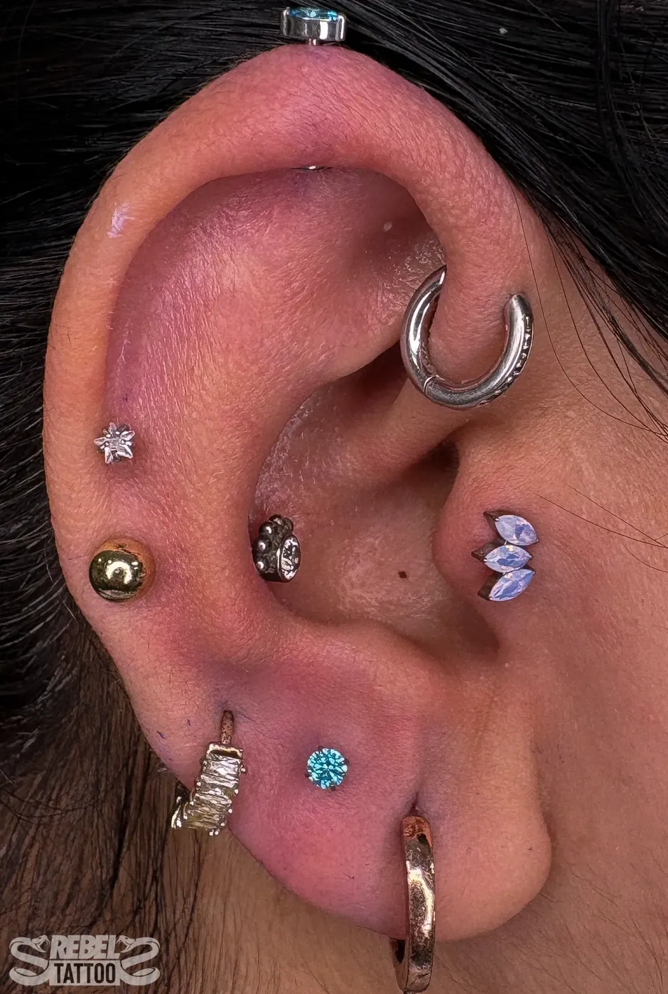 Full ear curation with mixed gemstone studs in implant grade titanium, multi piercing at Rebel Tattoos Gurgaon