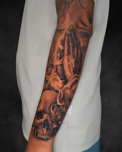 Praying Hands and Skull, realism tattoo on the outer forearm, black and grey, at Rebel Tattoos, Sector 67 Gurgaon